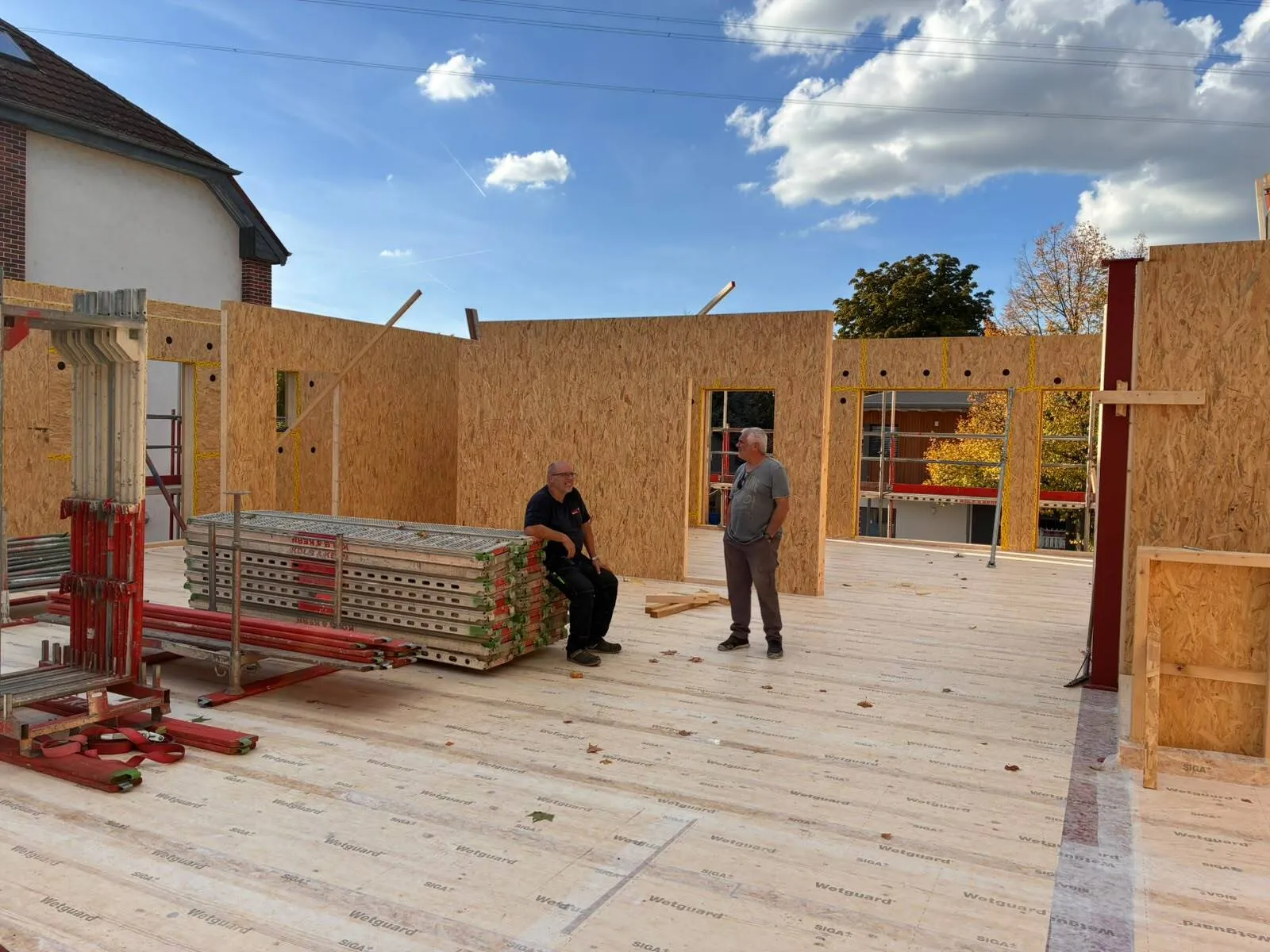 Bauteam auf dem neuen Holzboden zwischen den aufgestellten Wänden